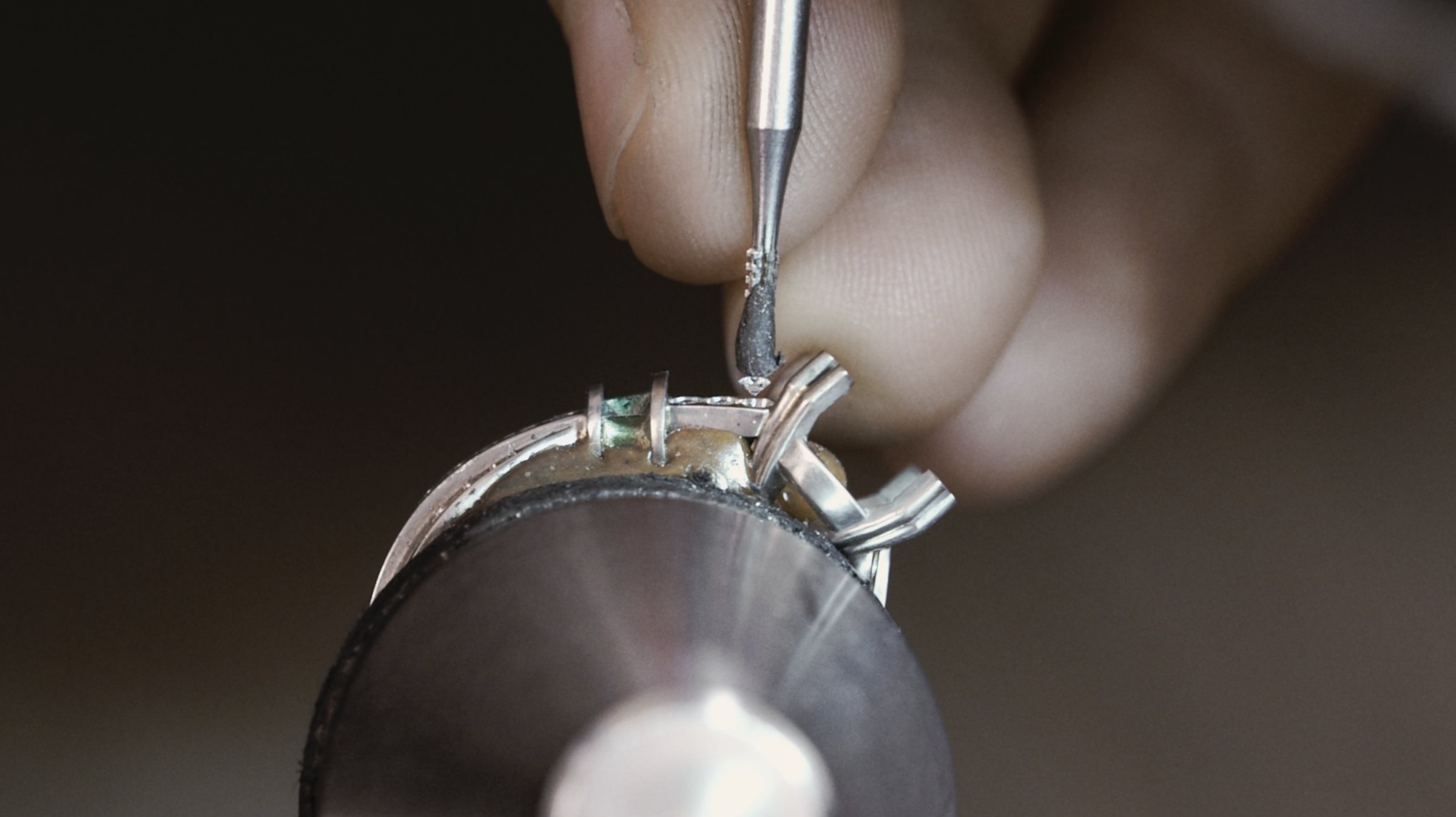 Sertissage d’une pierre sur une bague à l’atelier