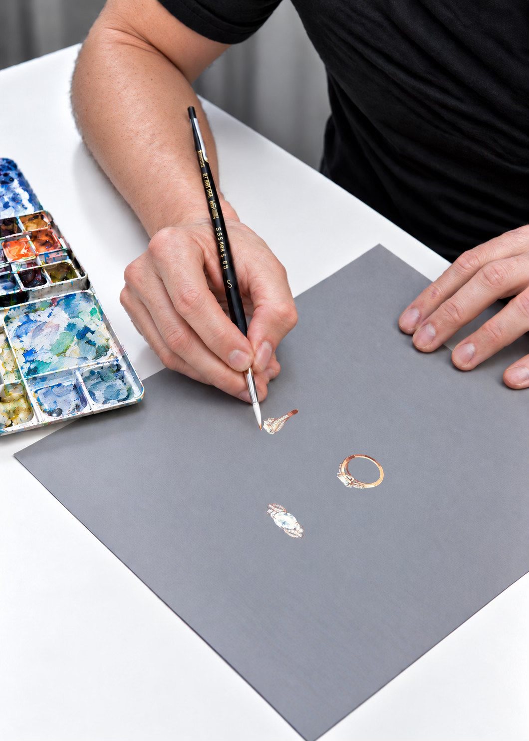 Dessinateur réalisant le dessin gouaché d’une bague